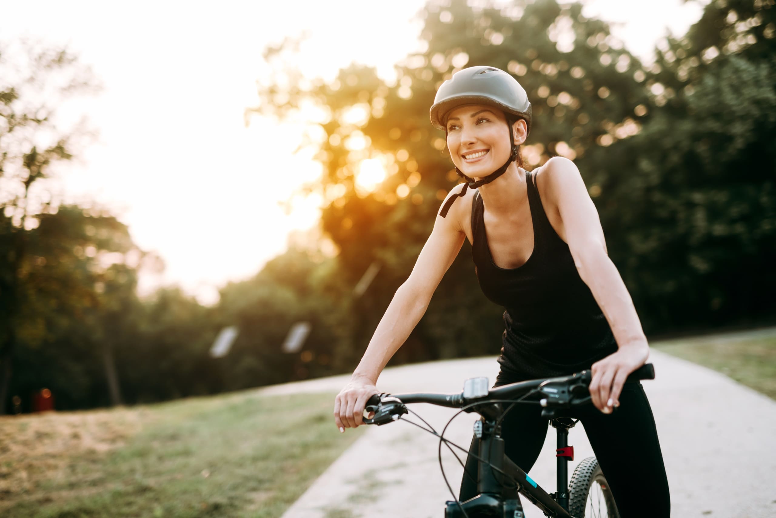 Junge Frau auf dem Fahrrad in einem Parkareal